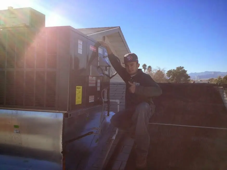 HVAC technician performing HVAC Inspection on a rooftop unit in Saratoga
